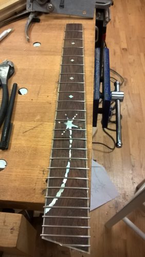 Frets installed. A few of the frets aren't fully seated yet.